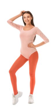 Beyaz arka planda aerobik yapan genç bir kadın.