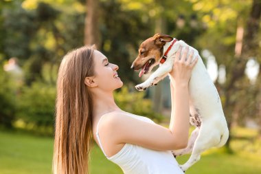 Dışarıda dolaşan sevimli köpekli genç bir kadın.