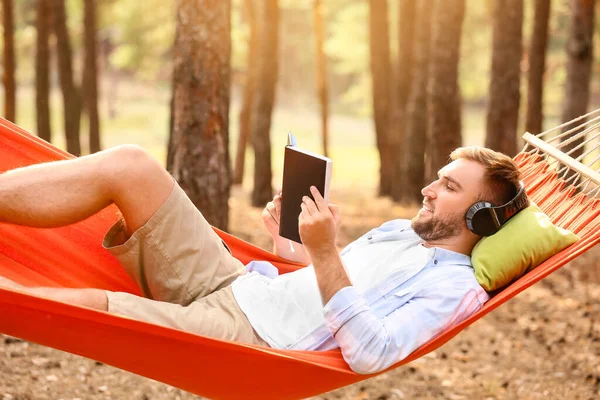 Jongeman Met Boek Ontspannen Hangmat Buiten — Stockfoto