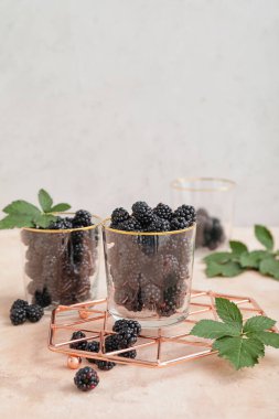Masada olgun böğürtlenli bardaklar