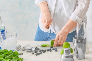 Masada lezzetli mojito kokteyli yapan bir kadın.