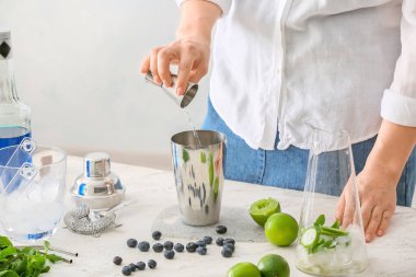 Masada lezzetli mojito kokteyli yapan bir kadın.