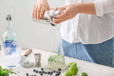 Masada lezzetli mojito kokteyli yapan bir kadın.