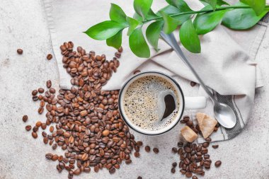 Masada bir fincan sıcak kahve ve fasulye.