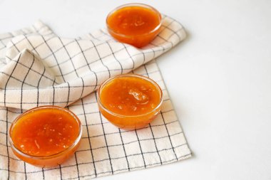 Beyaz arka planda şeftali reçeli kaseleri