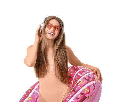 Kulaklık takan ve beyaz arka planda şişme yüzük takan genç bir kadın.