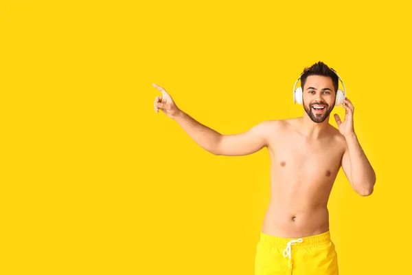 Hombre Joven Con Auriculares Que Muestran Algo Fondo Color — Foto de Stock