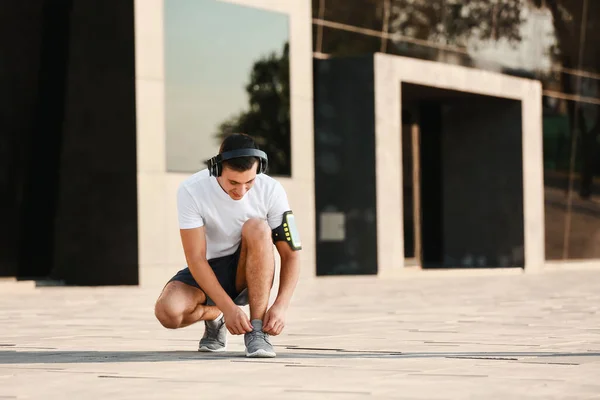 Sporty Young Man Tying Shoelaces Outdoors — Stock Photo, Image