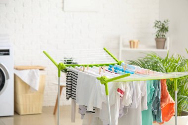 Çamaşır odasında temiz kıyafetler kurutucuya asılıyor.