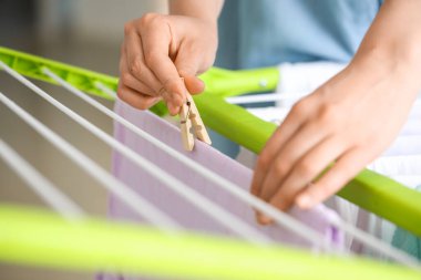 Çamaşır odasında temiz giysileri kurutucuya asan kadın, yakın plan.