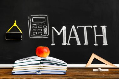 Kırtasiye ve elma sınıftaki masada.