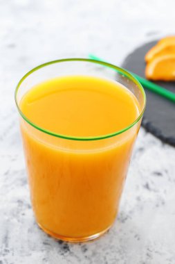 Masada bir bardak taze portakal suyu var.