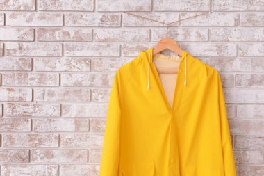 Koridordaki tuğla duvara asılı yağmurluk