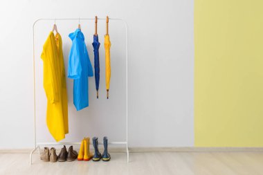 Koridorda yağmurluk ve şemsiyelerle dizilin.