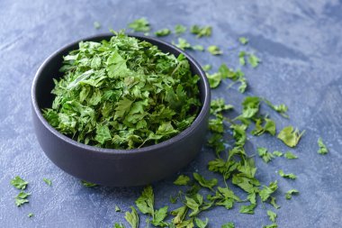 Koyu arkaplanda kuru maydanozlu kase