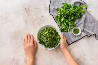 Hafif arka planda taze ve kuru maydanozlu kadın elleri