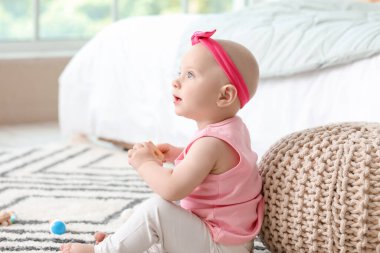 Evinde oyuncağı olan şirin bir bebek.