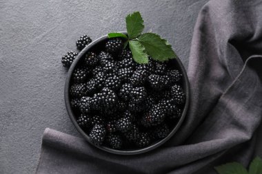 Koyu arkaplanda lezzetli böğürtlenli kase