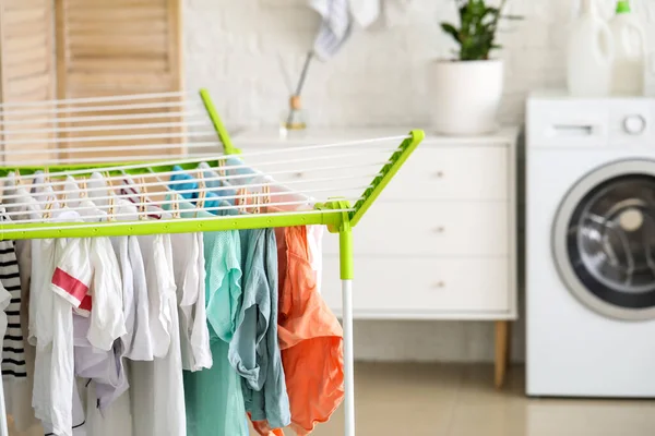 Clean clothes hanging on dryer in laundry room