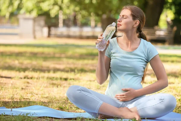 Young Pregnant Woman Drinking Water While Practicing Yoga Outdoors — Stock Photo, Image