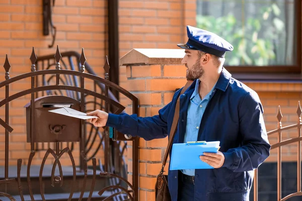 Jóképű Fiatal Postás Levelet Tesz Postaládába Szabadban — Stock Fotó