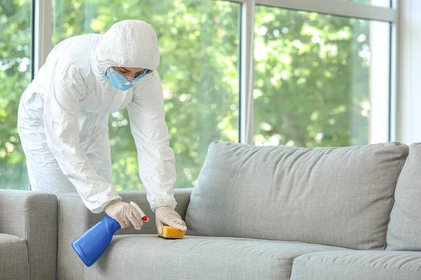 Biyolojik Tehlike Kostümlü Bir Işçi Evdeki Kanepedeki Kiri Temizliyor — Stok fotoğraf