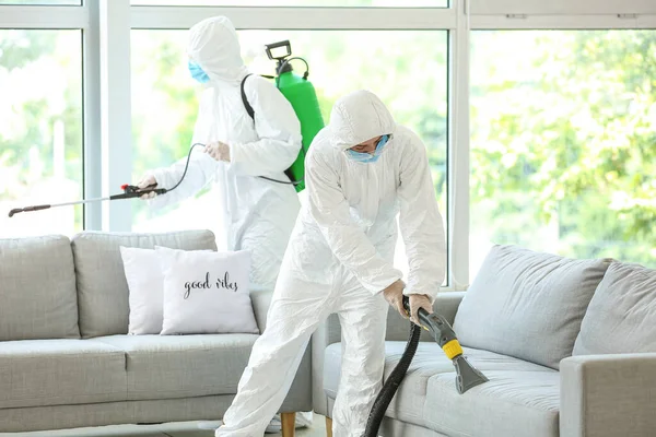 집안에서 먼지를 제거하는 생화학적으로 복장을 근로자들 — 스톡 사진