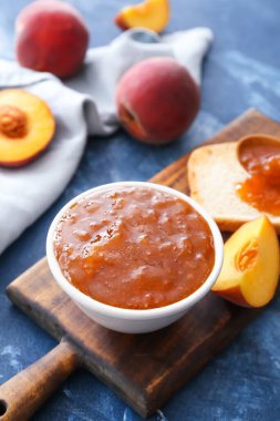 Arka planda bir kase lezzetli şeftali reçeli