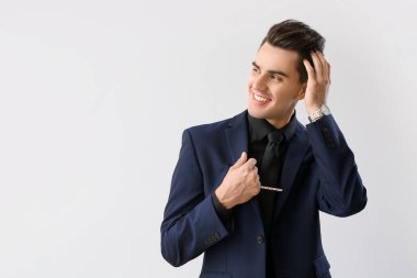 Açık arkaplanda şık saç stili olan yakışıklı adam.