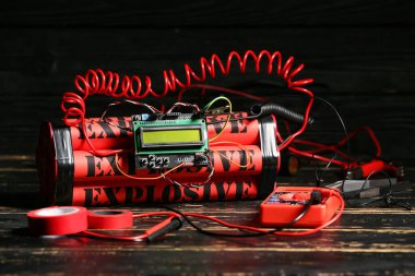 Masadaki bomba ve araçlar koyu arkaplana karşı