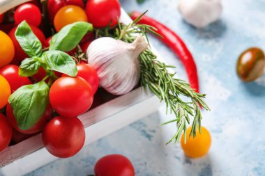 Taze kiraz domatesli sepet, masada otlar ve baharatlar, yakın plan.