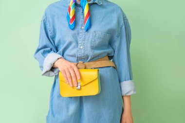 Kot pantolonlu güzel bir kadın. Arka planda renkli giysiler.