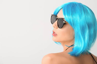 Aydınlık arka planda peruklu güzel bir kadın.