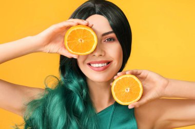 Peruklu ve turuncu arka planda güzel bir kadın.