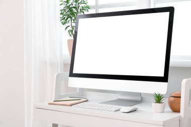 Pencerenin yanındaki masadaki modern PC monitörü