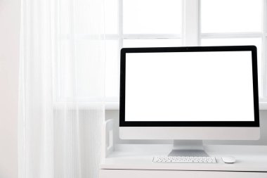 Pencerenin yanındaki masadaki modern PC monitörü