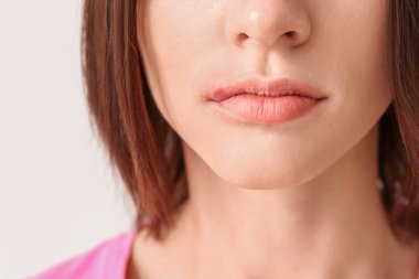 Hafif arka planda uçuk olan genç bir kadın, yakın plan.