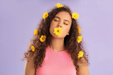 Genç Afro-Amerikalı kadın, güzel göz farları ve saçlarında çiçekler var.