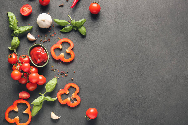 Composition with fresh cherry tomatoes, sauce and spices on grey background