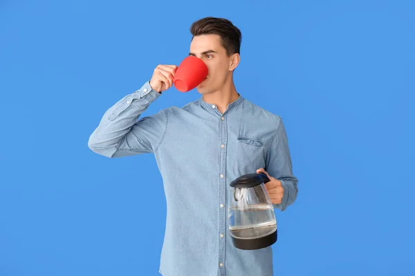 Jongeman Met Elektrische Waterkoker Drinken Koffie Kleur Achtergrond — Stockfoto