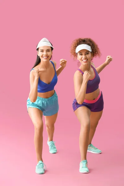 Mujeres Jóvenes Haciendo Aeróbicos Sobre Fondo Color —  Fotos de Stock