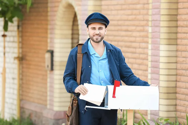 Jóképű Fiatal Postás Leveleket Tesz Postafiókba Szabadban — Stock Fotó