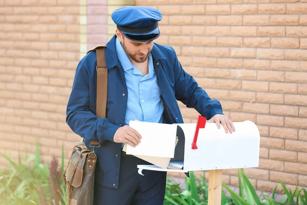 Handsome Young Postman Putting Letters Mail Box Outdoors — Stock Photo, Image