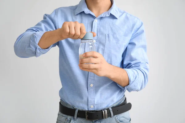 Ung Man Med Flaska Vatten Ljus Bakgrund — Stockfoto