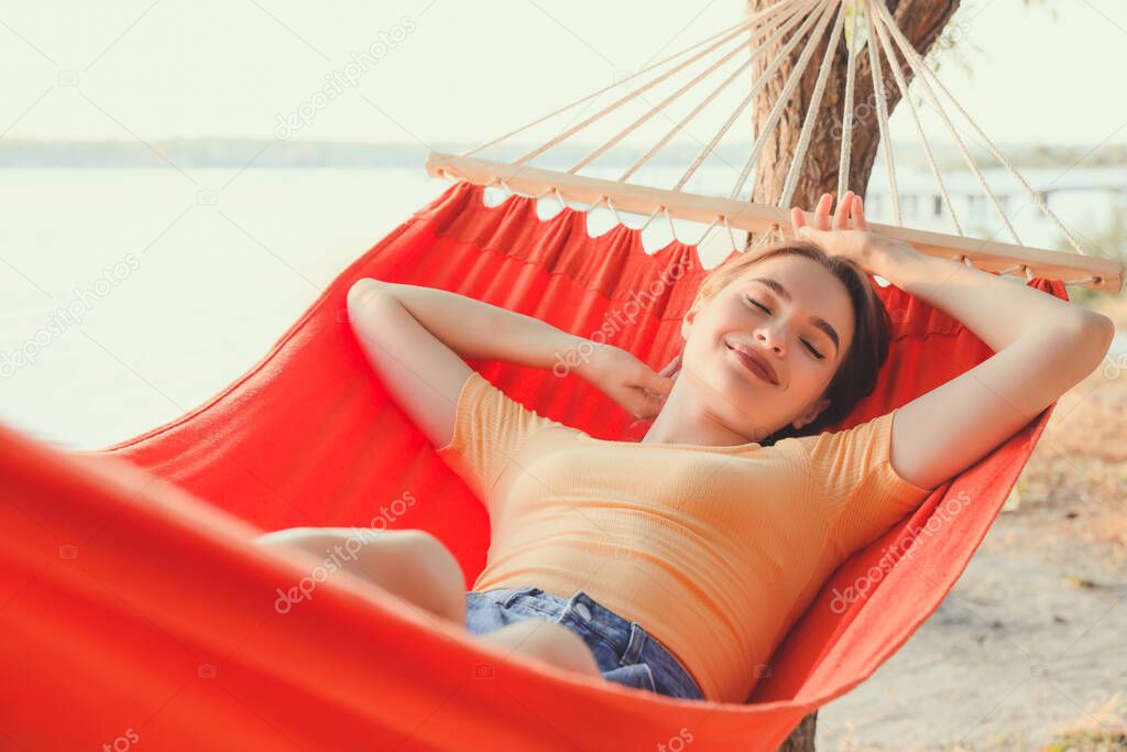 Young woman relaxing in hammock outdoors