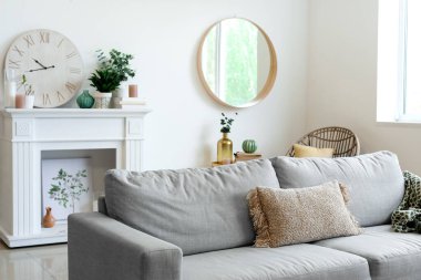 Ayna, şömine ve kanepesi olan şık bir oturma odası.