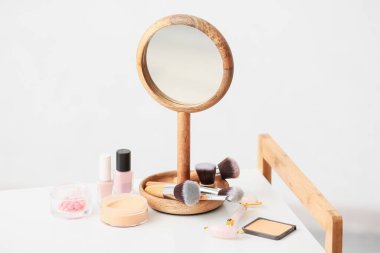 Masasında ayna olan makyaj malzemeleri.
