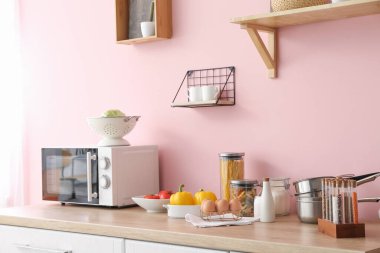 Mutfak tezgahında mutfak aletleri ve ürünleri var.