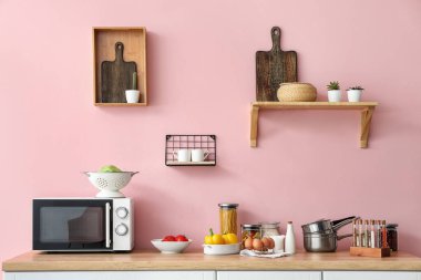 Mutfak tezgahında mutfak aletleri ve ürünleri var.