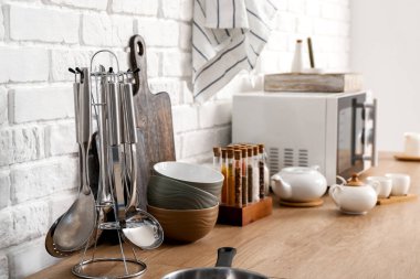 Mutfak tezgahında mikrodalga fırın olan mutfak gereçleri.